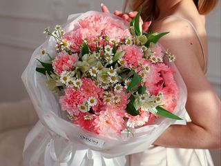 Bukiet z różowych goździków, rumianku i delikatnych dodatków kwiatowych