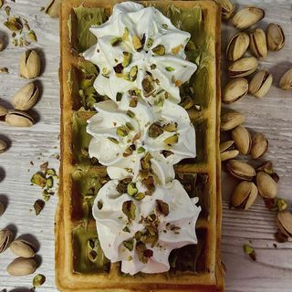 Goferek z sosem pistacjowym, białą czekoladą i bitą śmietaną