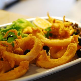 Pratinho de choco frito com arroz feijão e batatas fritas
