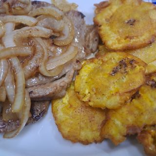 Carne de porco acebolada com 6 und banana pão (tostones cubanos) e sobremesa típica do dia.