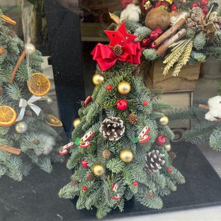 Pinheiro pequeno decorado em tons vermelho 