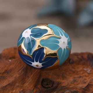 Anel dourado com pedra dourada e flores azuis