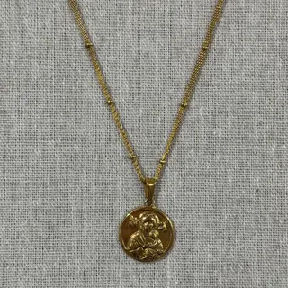 Colar em aço inoxidável dourado com figura religiosa
