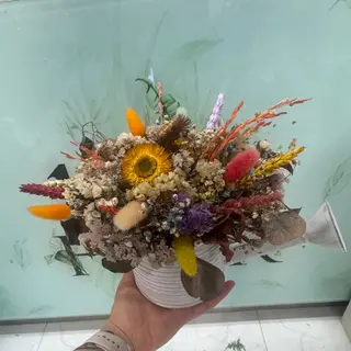 Regador branco com flores secas