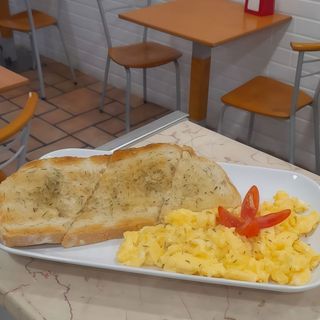 Ovos mexidos com uma fatia de pão Alentejano