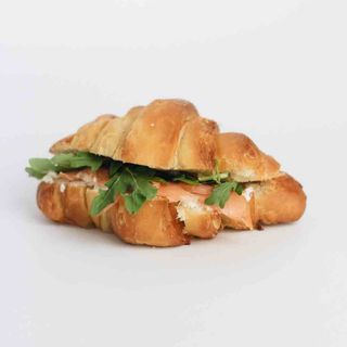 Croissant com salmão fumado, queijo creme e rúcula.