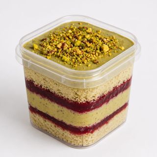 Bolo no pote pistache com frutos vermelhos.