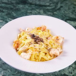 Fresh tagliatelle with shrimps, cognac reduction, truffles and garlic