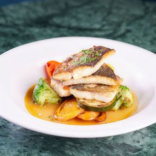 Oven cooked sea bass with small vegetables and capers