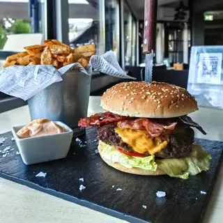 Burger de vită Black Angus picant cu cartofi prăjiți și sosul casei