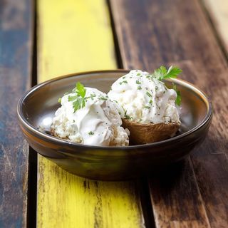 Whole baked potato with traditional sheep cheese and sour cream