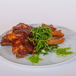 Scăriță de porc cu sos barbeque, cartofi rustici, mix de salată verde