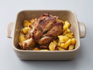 Ciolan de porc servit cu cartofi copti 