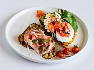 BRUSCHETTE CU CREMA DE BRANZA, ROSII, MOZARELLA, PESTO SI PROSCIUTTO