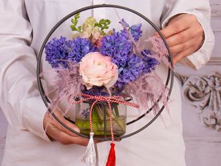 Aranjament de primăvară cu zambile și ranunculus în suport rotund