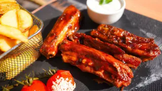 Costite BBQ cu cartofi prăjiți și sos de usturoi