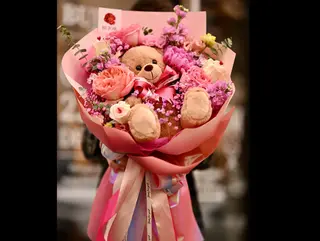 Buchet de flori mare, in nuante de roz cu ursulet de plus jucaus