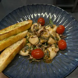Baby calamari cu lime, peperoncino, rosii cherry pe pat de rucola