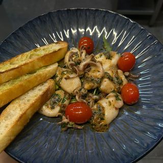 Baby calamari cu lime, peperoncino, rosii cherry pe pat de rucola