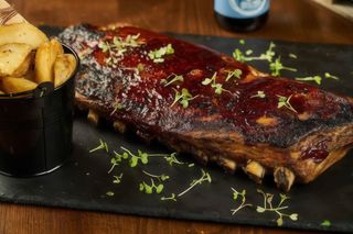 Coaste de porc cu sos bbq și cartofi steakhouse