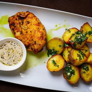 Piept de pui sous-vide servit cu cartofi aromatizați și sos de salvie