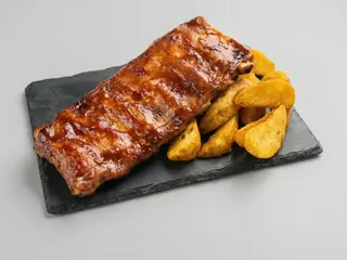 Coasta mare de porc cu sos BBQ si cartofi wedges