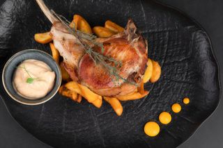 Tomahawk de porc cu cartofi wedges si sos spicy mayo