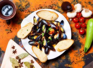 Midii in sos de vin alb si usturoi servite cu paine prajita