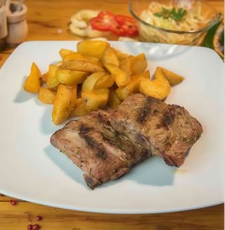 Costa de porc cu cartofi wedges si salata