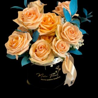 Aranjament elegant cu trandafiri peach și ruscus albastru – Cadou floral rafinat