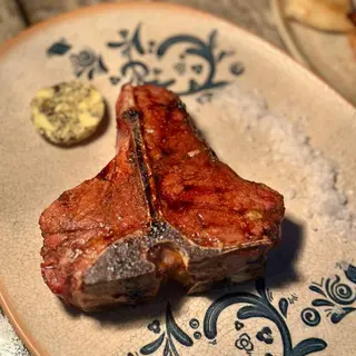 T-BONE gătit la foc deschis cu unt trufat cu ierburi de Provence