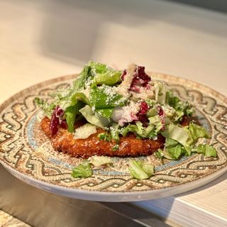 ȘNIȚEL DE VITĂ CROCANT în crustă de parmezan, mix salată cu arome de busuioc și cartofi prăjiț