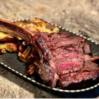 TOMAHAWK VITA DRY AGED gătită la foc deschis și unt trufat cu ierburi de Provence