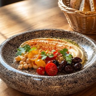 HUMMUS mediteranean cu roșii cherry, selecție măsline, nuci crocante si painea casei