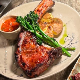 TOMAHAWK PORC PE JAR cu cartofi copți, broccolini și sos de roșii coapte