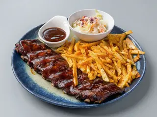Coaste de porc, sos BBQ afumat cu cartofi prajiti și salată coleslaw