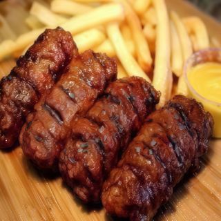 Mici însoțiți de cartofi prăjiți și de sosul de muștar 