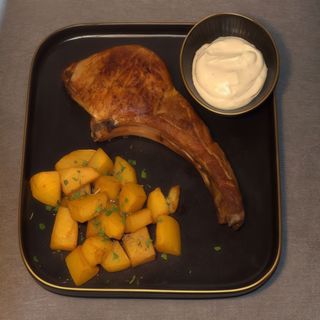 Tomahawk de porc cu sos gorgonzola și cartofi aurii