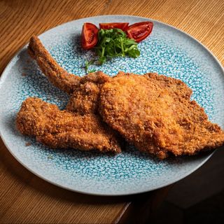 Snitel din cotlet de porc tomahawk cu branza de burduf, piure de cartofi, ou ochi si salata de varza