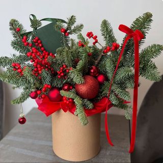 Aranjament de Crăciun cu brad natural, globuri roșii și bobițe decorative, în cutie kraft