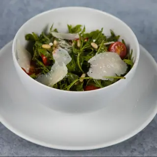 Rukola salata sa čeri paradajzom, parmezanom i pinjolima.