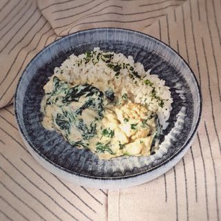 Fish in a creamy sauce with spinach and rice