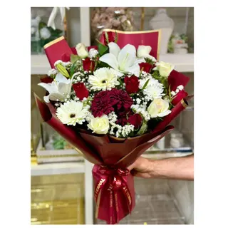 Bouquet rouge et blanc avec lys et gerberas, accompagné de bonbons.