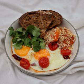 Яєчня оката з томатами на кремі з квасолі Ясь з чилі-кранч олією та пряними травами