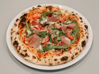 Піца з прошуто Крудо, томатами чері та руколою 