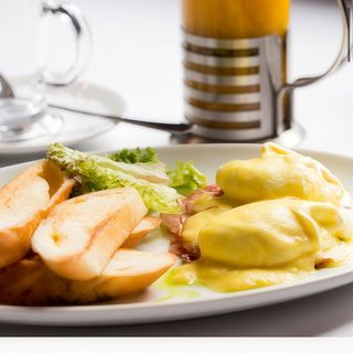 Яйця бенедикт з шинкою, голландським соусом і сирними тостами