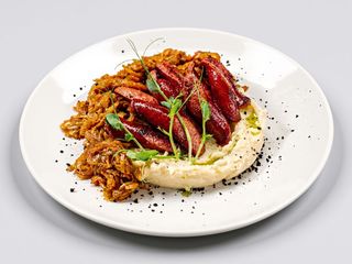 Тушкована капуста з копченими ковбасками та картопляним пюре