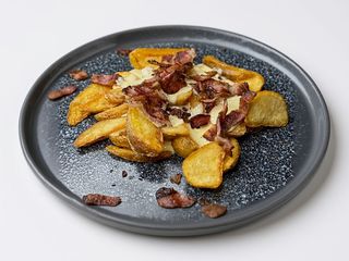 Картопля по-селянські з сирним соусом та беконом