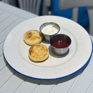 Сирники зі сметаною та полуничним соусом