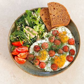 Яєшня з смаженою сосискою, зеленню та хлібом